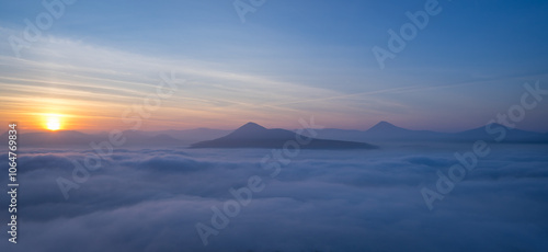 Hills in foggy evening. Radobyl hill in Czech Midland/ Ceske Stredohori, Czech republic