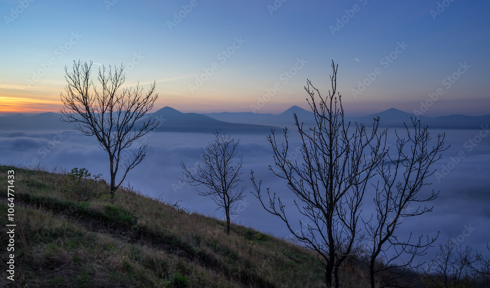 Hills in foggy evening. Radobyl hill in Czech Midland/ Ceske Stredohori, Czech republic Hills in foggy evening. Radobyl hill in Czech Midland/ Ceske Stredohori, Czech republic