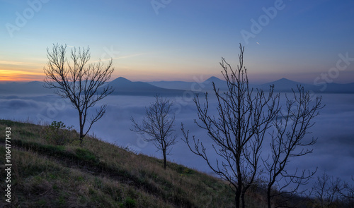Hills in foggy evening. Radobyl hill in Czech Midland/ Ceske Stredohori, Czech republic