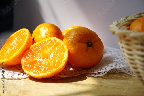 The half of orange fruit on the white lace and wooden with white background in the morning.Sunlight shining on orange fruit. photo