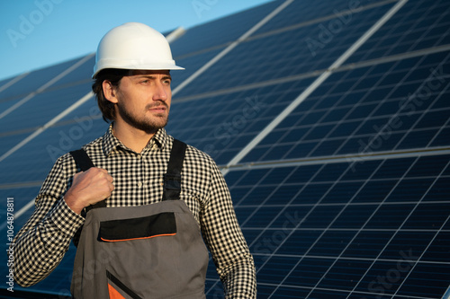 Man worker mounting photovoltaic solar panels. Engineer in helmet installing solar module system. Concept of alternative, renewable energy photo