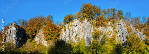 The “Sieben Jungfrauen” (Seven virgins) are a well-known limestone rock formation in the idyllic Hönne Valley in the Sauerland (Germany). Wide-angle panorama on sunny a autumn ay with colorful leaves photo