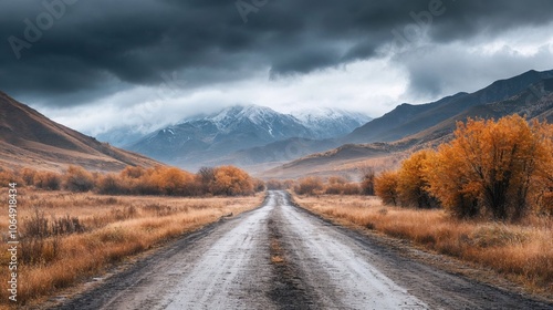 A dramatic mountain landscape with a wet road leading through autumn fields towards snow-capped peaks under stormy clouds, featuring golden foliage and moody atmosphere