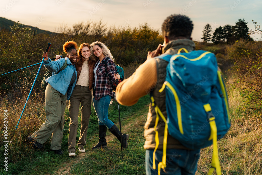 Smiling group of diverse hikers posing for a photo on a trail. Smiling group of diverse hikers posing for a photo on a trail.
