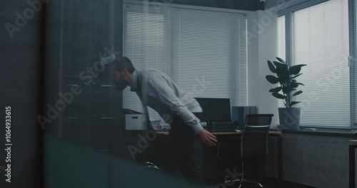 Aggressive businessman loses his temper in a fit of rage. Furious and angry male office employee throws things and papers off the shelf, yells and destroys office room. Financial crisis or dismissal.