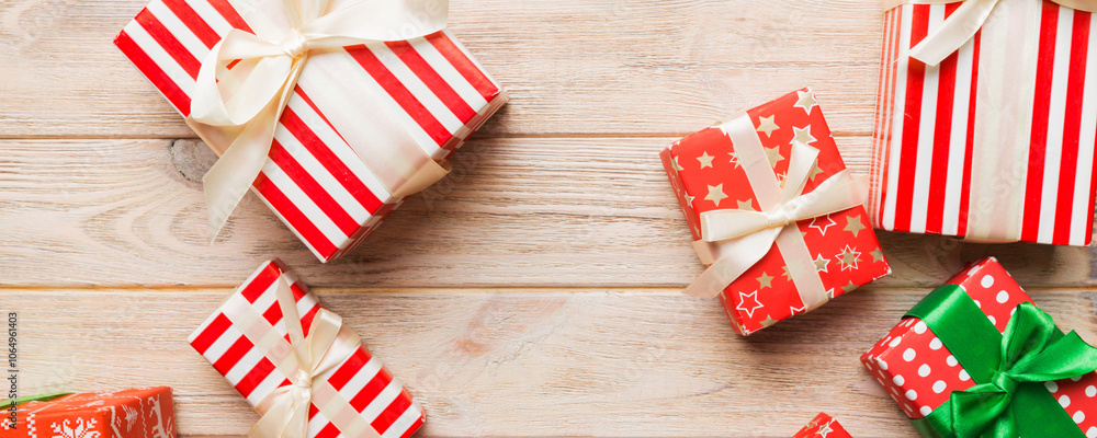 Fototapeta premium A lot of Christmas gift boxes in colored paper decorated on table, Top view close up. Many present New Year gift