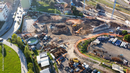 Vista aérea de um canteiro de obras com máquinas pesadas em operação, capturada por drone., Imagem aérea de uma área de construção industrial com grandes caminhões e guindastes, destacando a movimenta photo