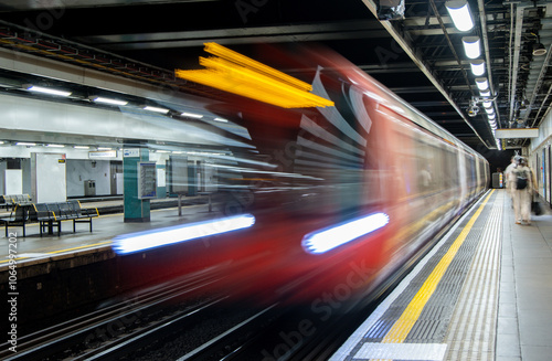 A Passing High Speed Passenger Train Flying Past A Train Station Platform