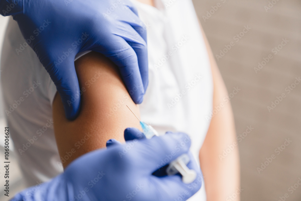 Cropped closeup image of doctor nurse in protective gloves taking shot with syringe making injection vaccine patient in forearm. Coronavirus Covid19 vaccination concept Cropped closeup image of doctor nurse in protective gloves taking shot with syringe making injection vaccine patient in forearm. Coronavirus Covid19 vaccination concept