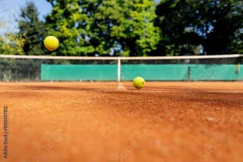 close-up of professional tennis a court with red clay surface with drawn markings of zones with tennis balls lying on it bounce off the field photo