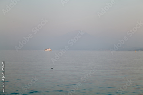 Ferry boat sailing at sunset on the Garda Lake in Italy photo