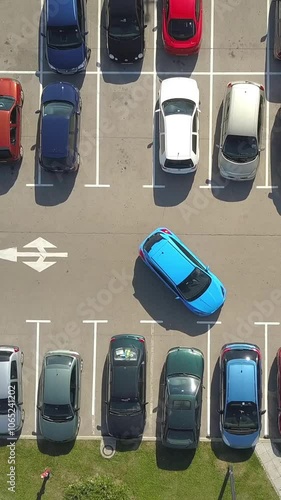 AERIAL TOP DOWN: Flying above female bad driver incapable to park a car on parking space in crowded parking lot. Woman having problems, unable to park a car in parking spot. Parking fail on parkspace