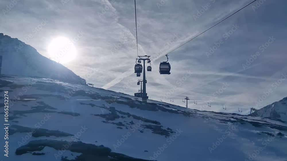 Overhead cable car ride on a sunny snow day. Hintertuxer glacier in snow mountains in Europe Alps. Ski resort on a beautiful sunny day.