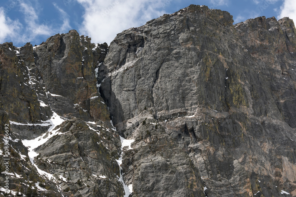 Fototapeta premium Rugged Granite Cliff Face with Snow Patches in Rocky Mountain National Park, Colorado