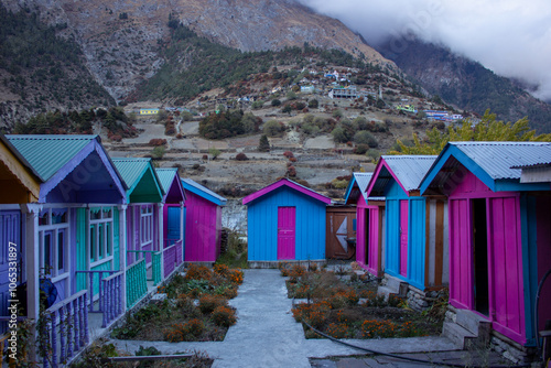 Colorful houses below the Himalayan village of Upper Pissang in Nepal photo