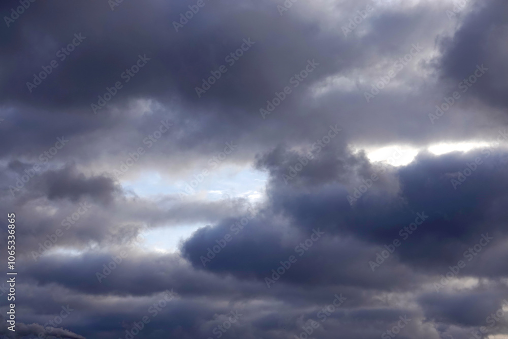 Fototapeta premium Overcast stormy weather with heavy gray rainy cumulus clouds in the sky