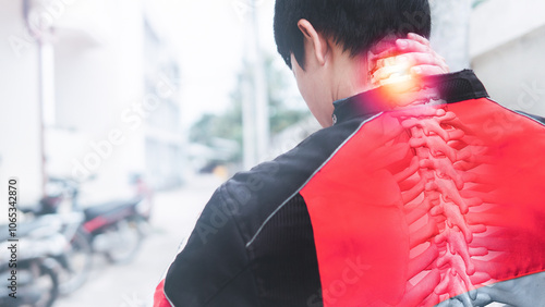 A motorcyclist stands, experiencing a twinge of cervical spine pain, clad in a futuristic ensemble and clutching a helmet, representing a fusion of technology and human anatomy