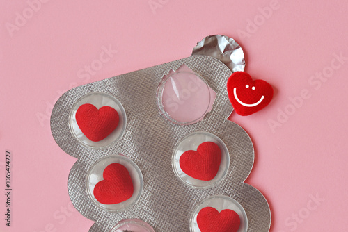 Close-up of heart shaped pills in blister on pink background - Concept of love and medicine photo