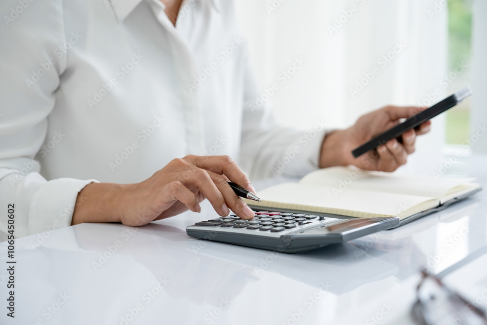 Fototapeta premium Businesswoman is working using calculator and phone.