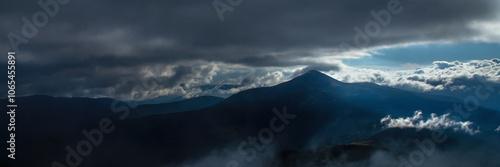 Fog and clouds in the mountains, clouds and nebula on mountain peaks. Beautiful nature. Horizontal image.