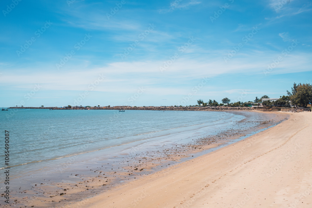Fototapeta premium Tropical sea beach with fishing boat by stone jetty in summer