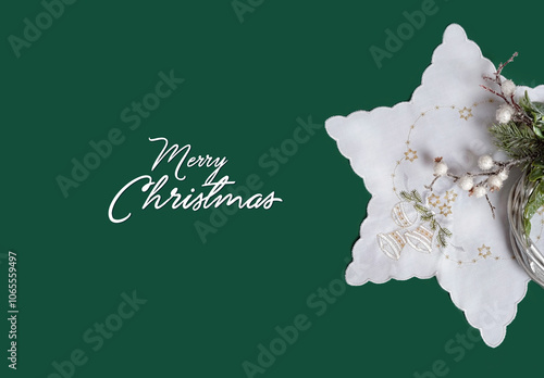 Merry Christmas greeting card. christmas napkin and decorative wreath on green background. embroidered christmas bells, fir branches, stars on white fabric. Christmas holiday, festive winter season.