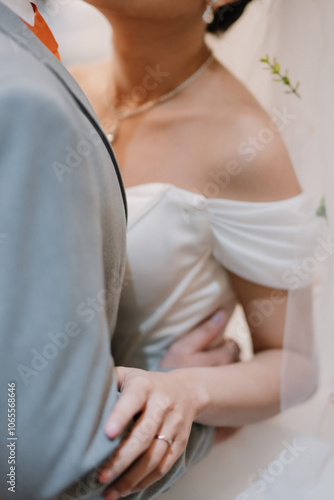 Close-up of the bride and groom holding hands