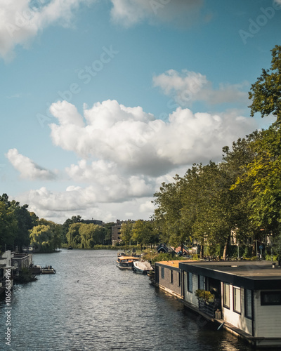 Photography Houseboats Along a Canal Under a Cloudy Sky in Amsterdam
