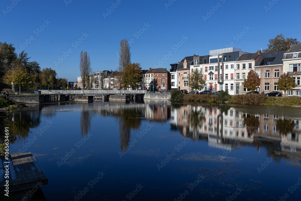Fototapeta premium View of the Old Dender River and the Old Sas (Locks) at Dendermonde in East Flanders, Belgium. Sunny autumn day with blue sky and copy space.