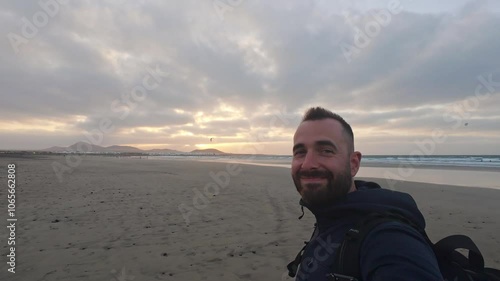 Man gazes at a stunning sunset over the beach in Lanzarote during early evening