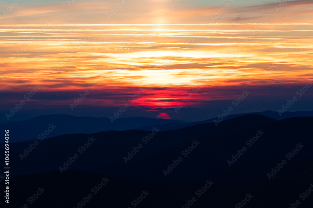 Fototapeta premium amazingly beautiful multicolored sky in the mountains at sunset. red sun
