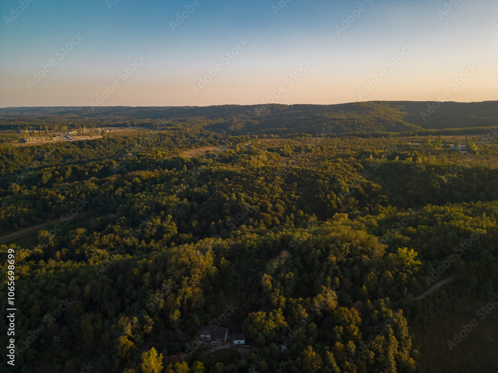 Fototapeta premium Rural landscape viewed from the drone. A village in Romania located on the edge of a lake near the wild forest