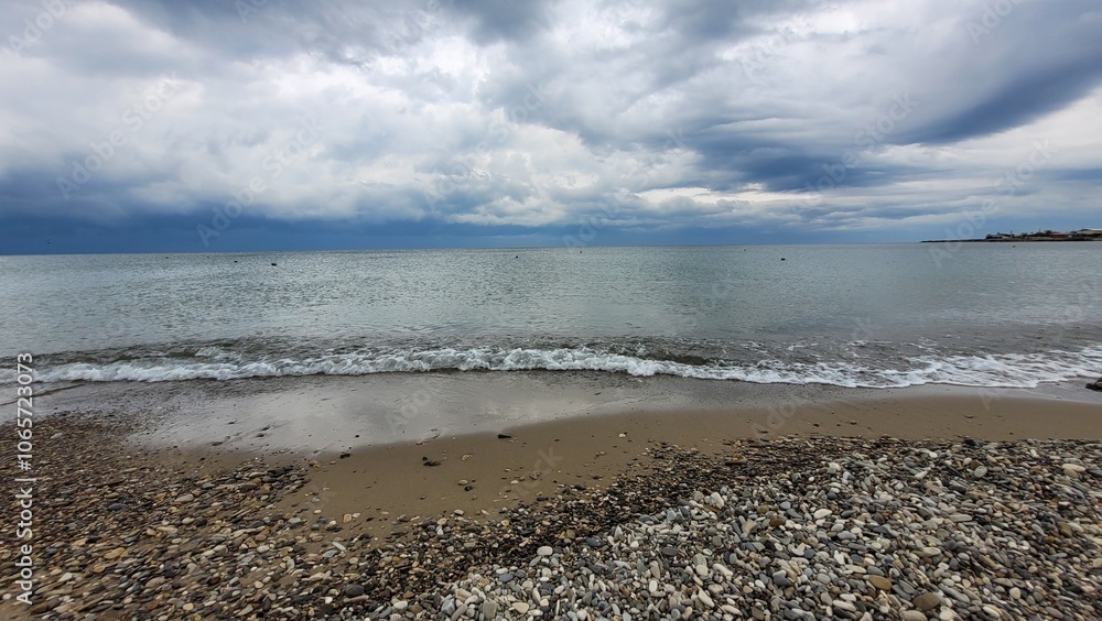 Sea, beach and pebbles, clouds in the sea.