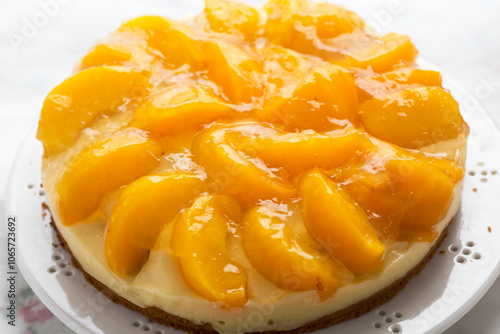Cake with vanilla cream, peaches and white glaze 