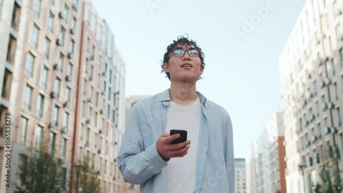 Young man browsing on smartphone and looking up