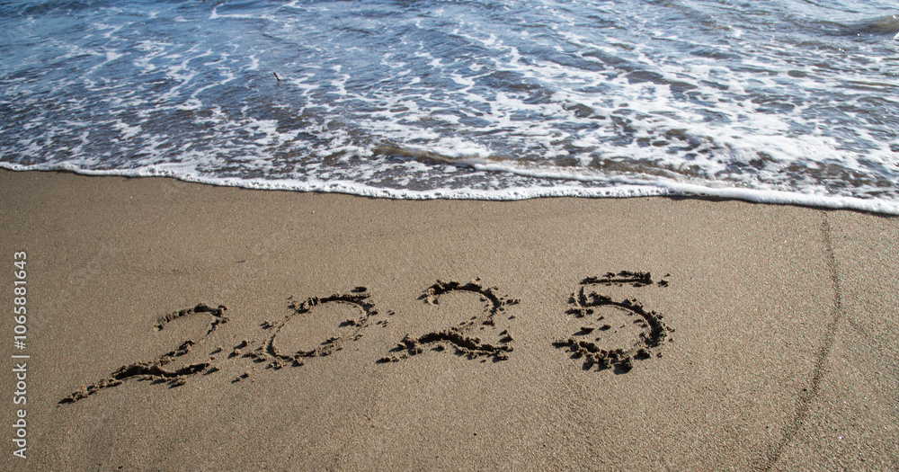 Fototapeta premium tropical New Year 2025 written in sand on the beach