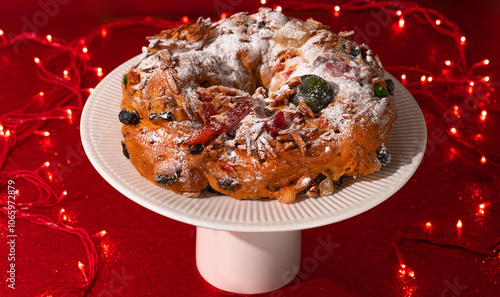 Foto Portuguese Bolo Rei is a traditional Chrismas cake with fruits and icing on red