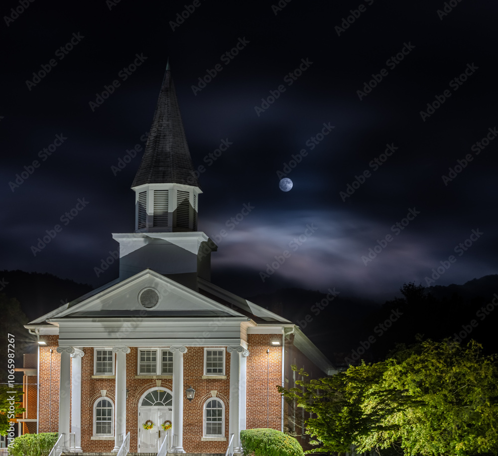 Historic Church Building Illuminated at Night with Moonlit Sky