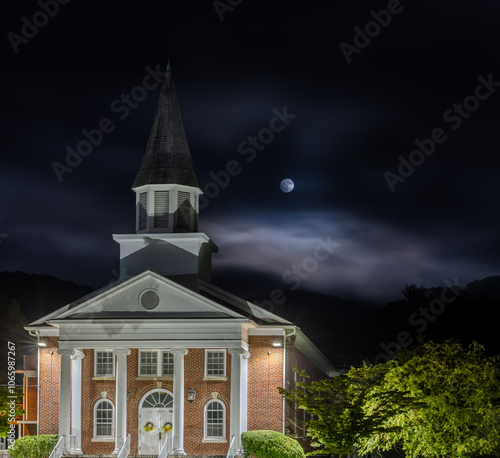 Obraz na płótnie Historic Church Building Illuminated at Night with Moonlit Sky w salonie