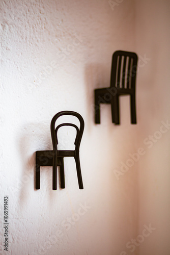 Black hang chair shaped in a white wall decoration still photo