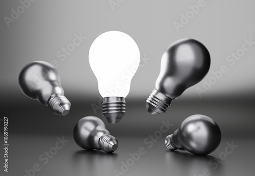 glowing light bulb surrounded by metallic light bulbs