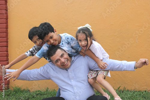 Single Dad with two brown latino sons and daughter spend time together and have fun to celebrate Father's Day in poverty photo