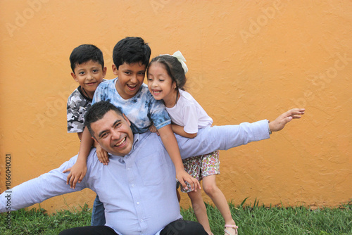 Single Dad with two brown latino sons and daughter spend time together and have fun to celebrate Father's Day in poverty