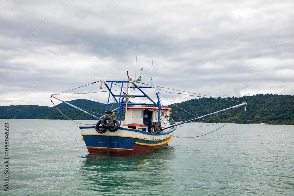 Fototapeta premium Fishing boat in Paraty Bay, a tourist town and World Heritage Site in Rio de Janeiro, Brazil