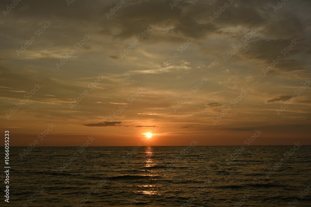 Fototapeta premium Serene sunset over a calm ocean