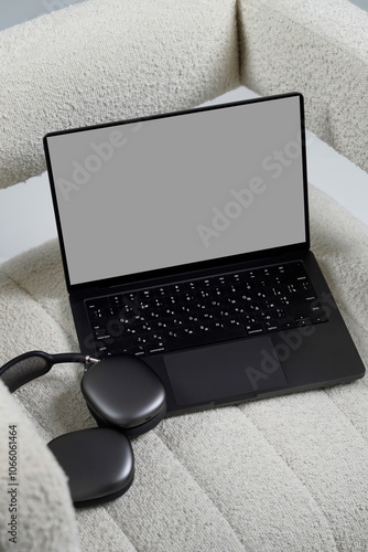 Laptop mockup with modern wireless headphones, realistic mockup, laptop on the chair photo