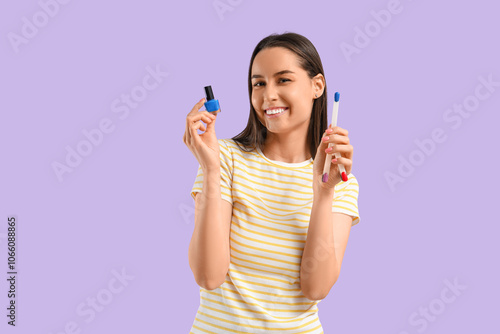 Young woman with nail polish palette and bottle on lilac background