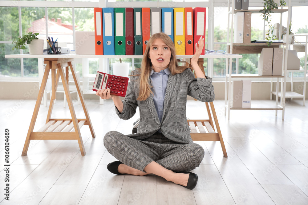 Εκτύπωση καμβά Young female accountant holding calculator and sitting on floor near table with