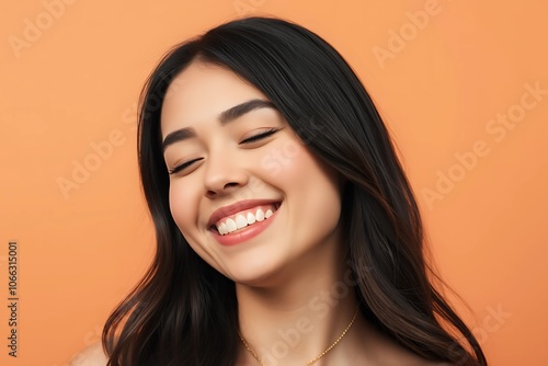 Smiling woman with eyes closed, isolated against a brown background