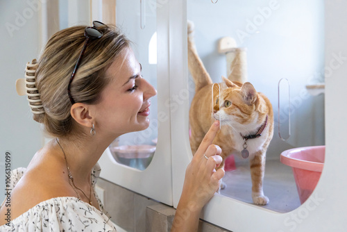 Quadro su tela Caucasian woman visiting pet shelter looking for adopting cat while meeting and